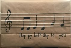 a brown paper bag with music notes on it and the words happy birthday to you