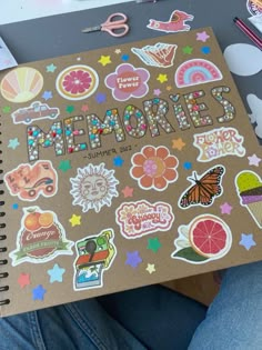 someone is holding a notebook with stickers on it