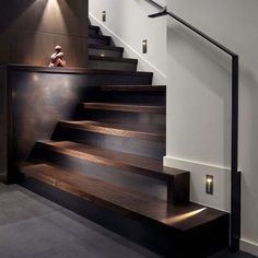 the stairs in this modern home are made of wood and metal, with lights on either side