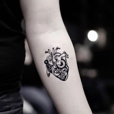 a woman's arm with a heart tattoo on it