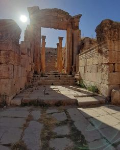 the sun shines brightly through some ancient ruins