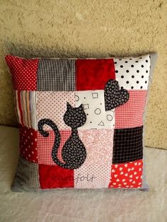 a patchwork pillow with a black cat on it