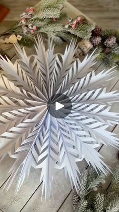 a paper snowflake sitting on top of a wooden floor next to christmas decorations