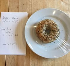 a donut sitting on top of a white plate next to a note