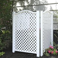 a white gate sitting next to a flower garden