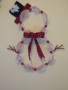 a red and white christmas wreath made out of mesh with bells, bows and beads