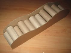 an open cardboard box filled with rolled up doughnuts on top of a wooden table