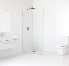 a white bathroom with a toilet, sink and shower