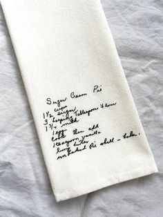 a piece of cloth with writing on it sitting on top of a white tablecloth