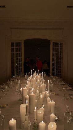 a long table with many lit candles on it