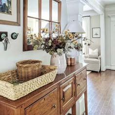 a basket sitting on top of a wooden table next to a lamp and window sill