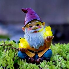 a gnome figurine is sitting in the grass