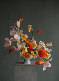 a vase filled with lots of different colored flowers