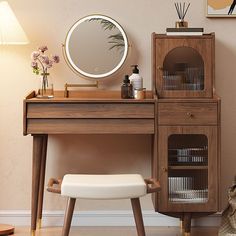 a wooden desk with a mirror, stool and other items on top of it in front of a wall