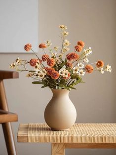 a vase filled with flowers sitting on top of a wooden table