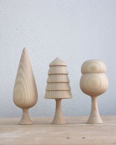 three small wooden trees sitting on top of a table