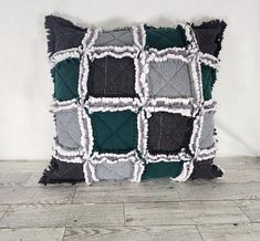 a black and grey pillow with squares on it