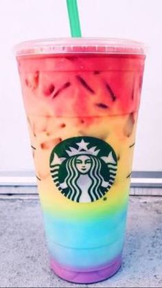 a rainbow colored drink with a straw in it