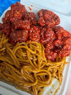 some spaghetti and meatballs are in a plastic container