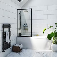 a white tiled bathroom with a black framed shower