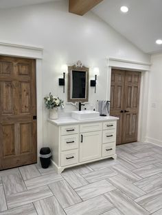 a bathroom with double sinks and wooden doors