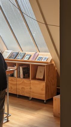 a man standing in front of a book shelf filled with books