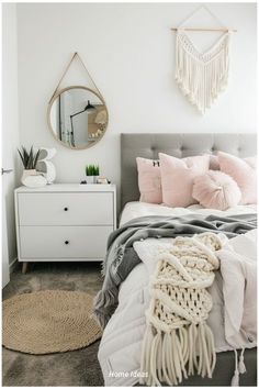 a bedroom with a bed, dresser and mirror on the wall next to each other