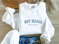 a white shirt with the word boy mama on it next to some shoes and a hat