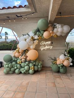 balloons and greenery decorate the entrance to a birthday party