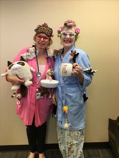 two women dressed up in costumes holding stuffed animals and coffee mugs while standing next to each other