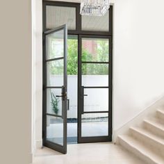 an open door leading to a patio with stairs and a chandelier hanging from the ceiling