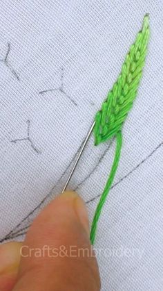 someone is stitching on the fabric with green thread