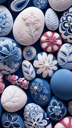 many different colored rocks with flowers and leaves painted on them, all in the same color