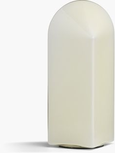 a white vase sitting on top of a table