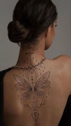 the back of a woman's neck with a butterfly tattoo on it