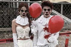 two people dressed up as clowns holding red balloons