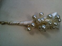 a bridal bouquet with pearls and ribbon on the table top, ready to be used as a brooch