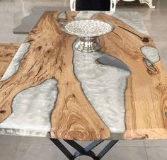 a table made out of wood and glass with a bowl on the top, surrounded by chairs