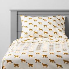 a bed with leopards on it and white sheets