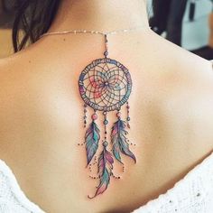 the back of a woman's shoulder with a colorful dream catcher tattoo on it