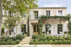 a large house with lots of windows and bushes