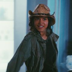 a woman wearing a cowboy hat and jacket