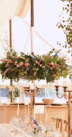 the table is set up with flowers and candles for an elegant wedding reception at the beach