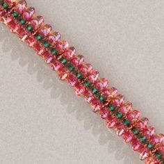 a pink and green beaded bracelet on a white surface