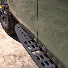 the front bumper and tire treads of a green car