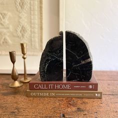 a book sitting on top of a wooden table next to two candles and a candle holder