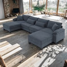 a large sectional couch sitting on top of a wooden floor in a living room next to a fire place