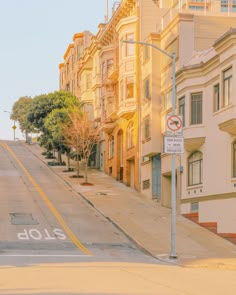 an empty street with no cars on it and buildings in the backgrouds