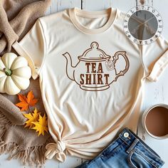 Our "Tea Shirt" T-shirt features an adorable nostalgic teapot with a tea bag hanging out and the playful words "Tea Shirt" on the front, making it the perfect gift for tea lovers and wordplay enthusiasts alike! Whether you're lounging with a warm cup of tea or looking for a cozy, cute outfit, this shirt brings charm and comfort to your wardrobe. Each shirt is custom-made to order, ensuring you get a truly one-of-a-kind piece. Please note that due to the custom nature of our products, we do not accept returns or refunds. Feel free to reach out with any questions prior to your purchase! Tea Shirt, Tea Lovers, Brewing Tea, Hot Tea, Tea Kettle, Herbal Tea, T Shirt Funny, Tea Pot, Iced Tea