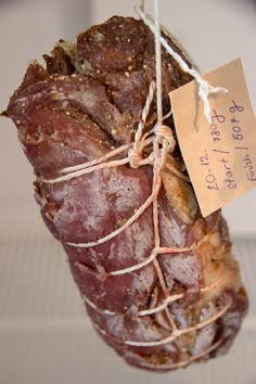 a piece of meat wrapped in twine and tied to a string with a tag